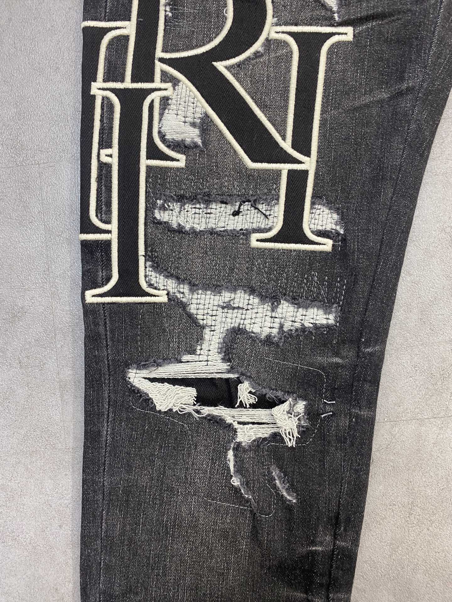 AMIRI jeans with a distressed finish, embroidered logo on the side