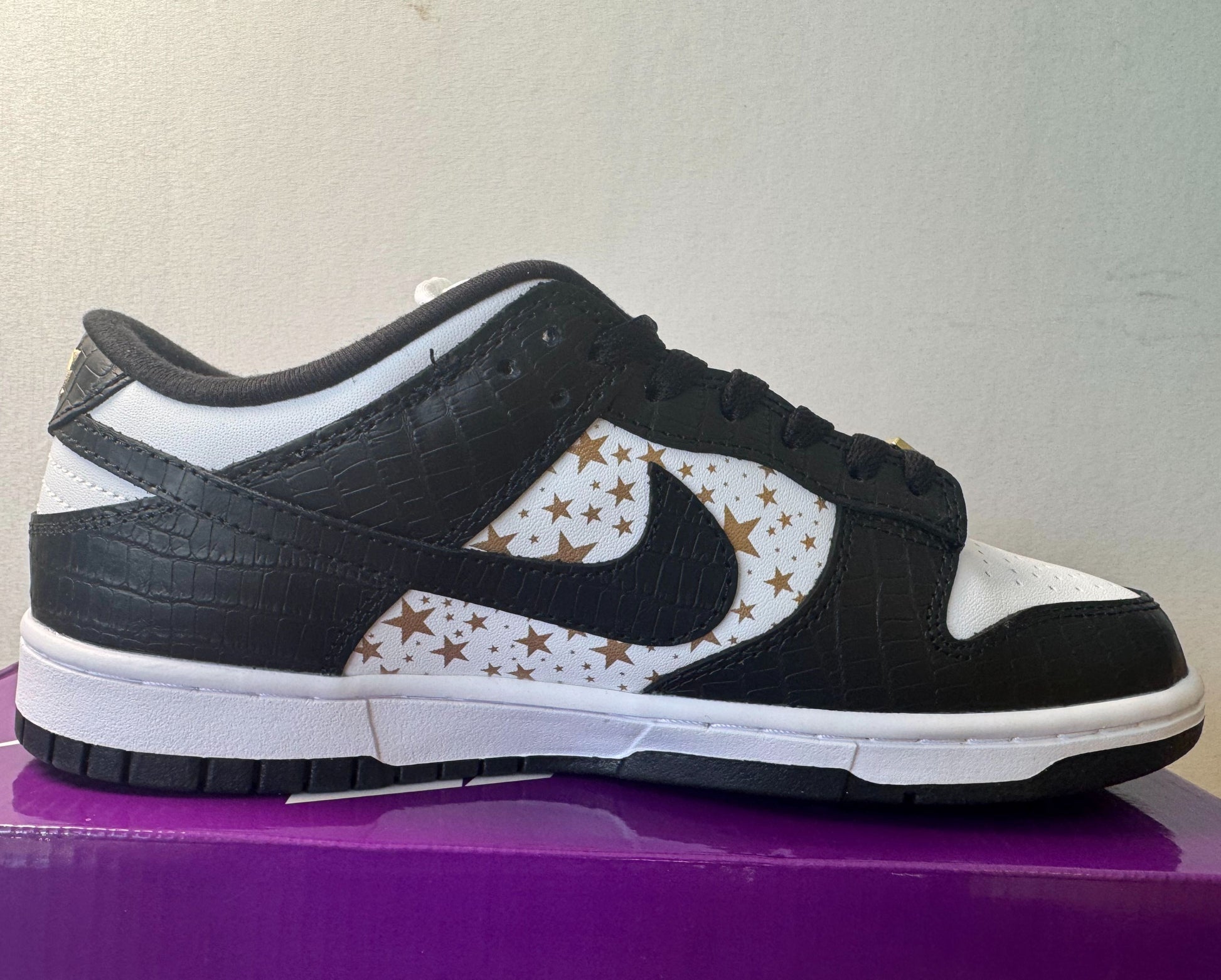 Supreme × Nike SB Dunk Low OG QS "Gold Stars" White/Black