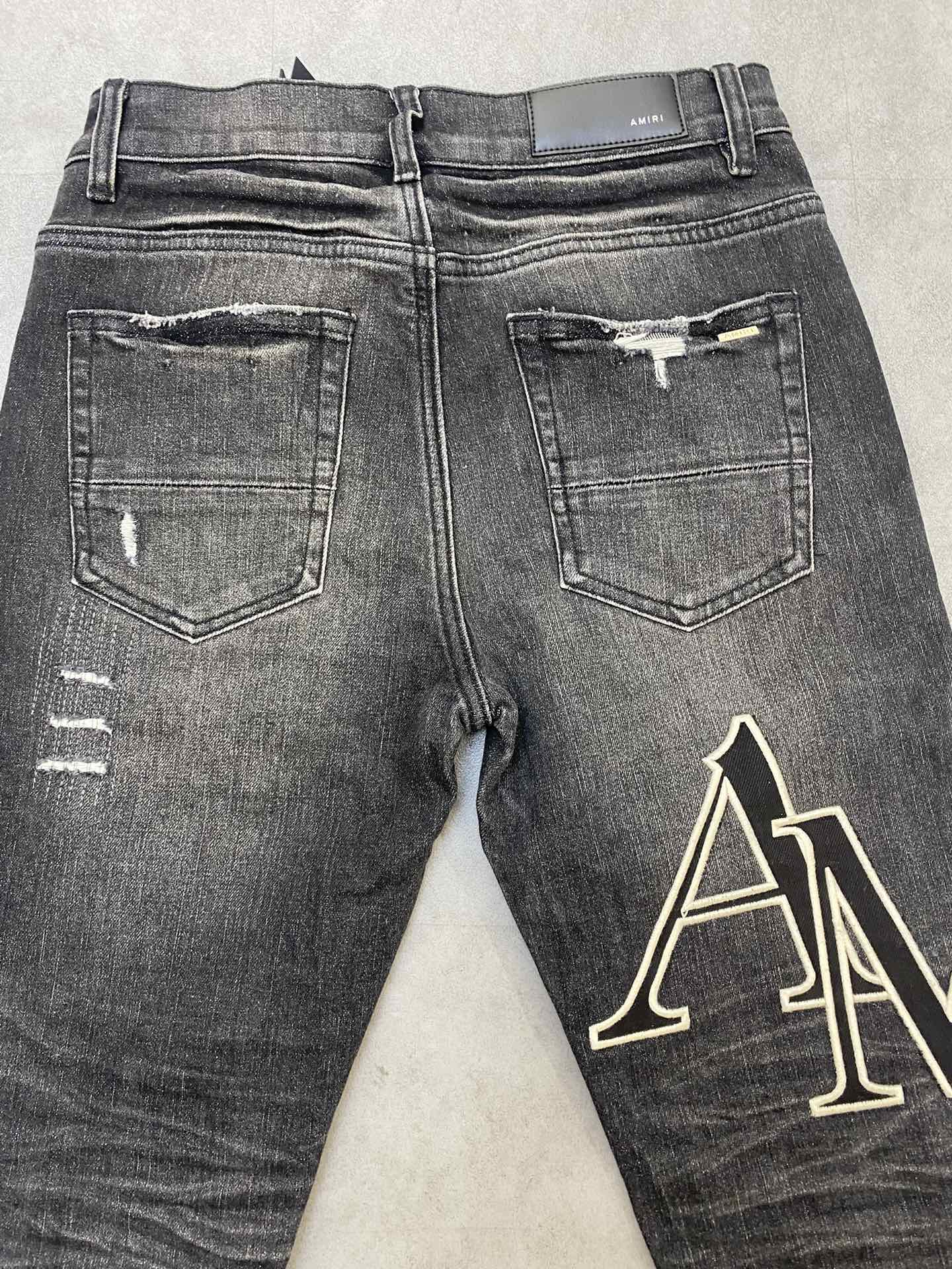 AMIRI jeans with a distressed finish, embroidered logo on the side