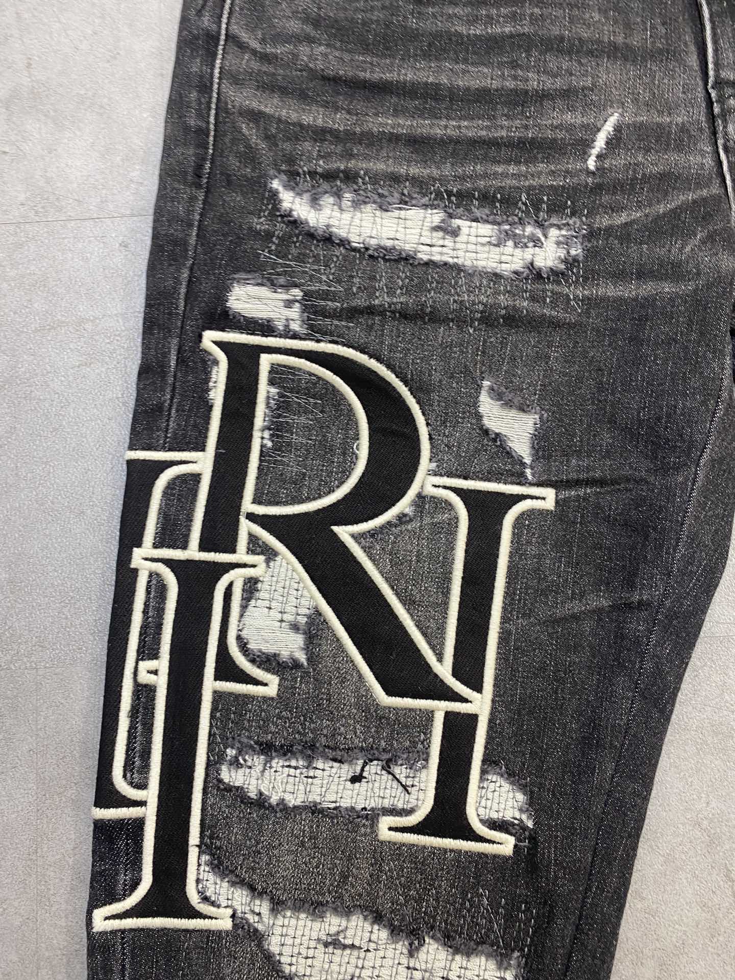 AMIRI jeans with a distressed finish, embroidered logo on the side