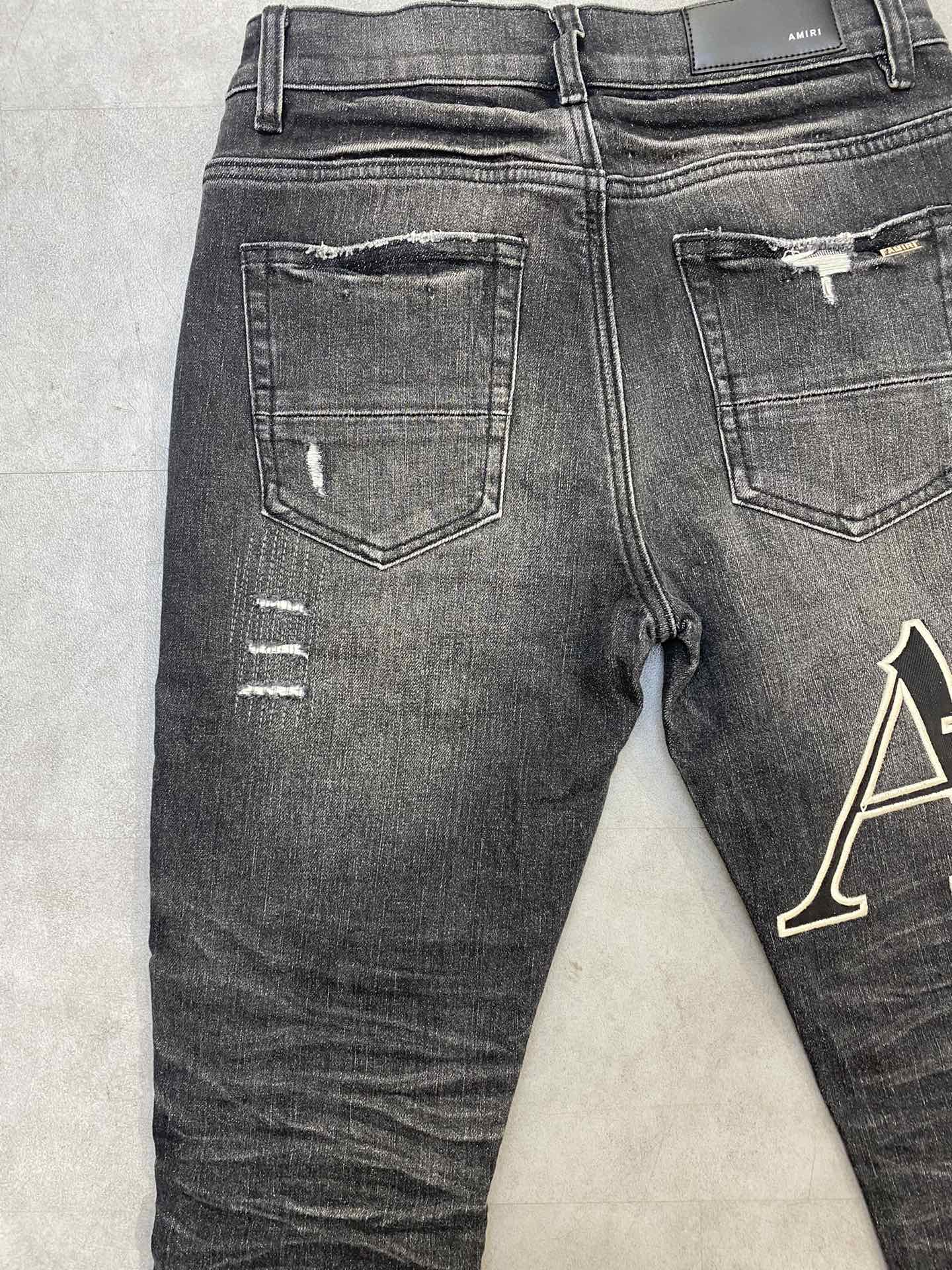 AMIRI jeans with a distressed finish, embroidered logo on the side
